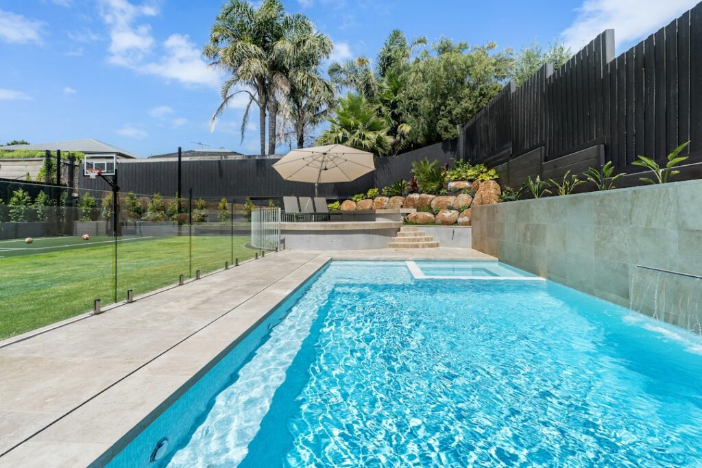 Backyard swimming pool enclosed by a compliant safety fence in NSW