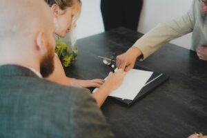 Couple signing a property contract at a desk
